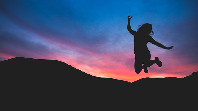 Silhouette of a girl jumping at sunset