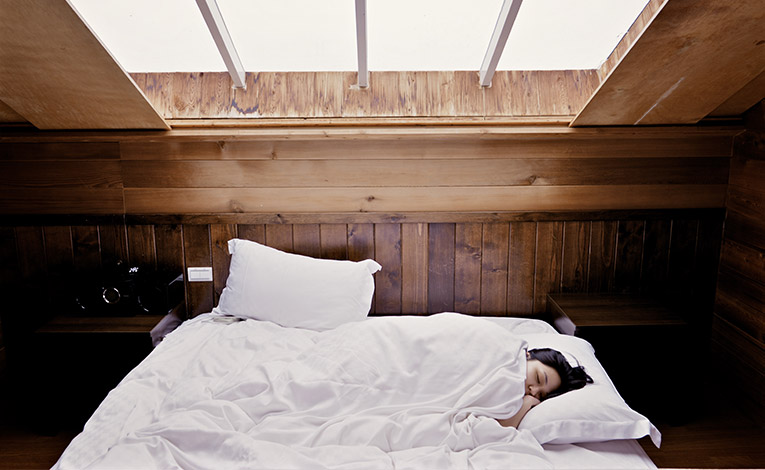 Girl sleeping in a bed with white sheets