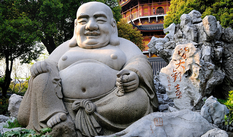 Laughing buddha in front of a temple