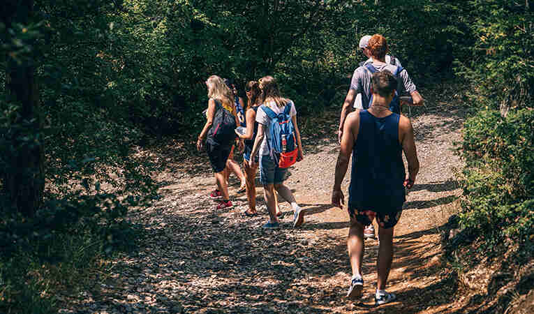 youth walking down a dirt path in the forest