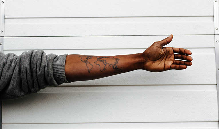 world map tattoo on mans arm