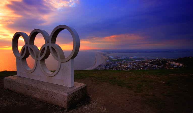 olympic rings monument overlooking beach at sunset