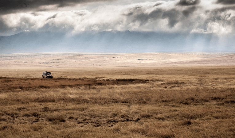 jeep driving across savannah in Tanzania